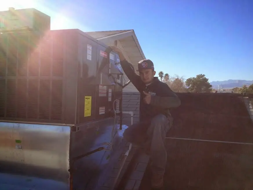 HVAC technician performing Air Duct Cleaning on a rooftop unit in Margaret